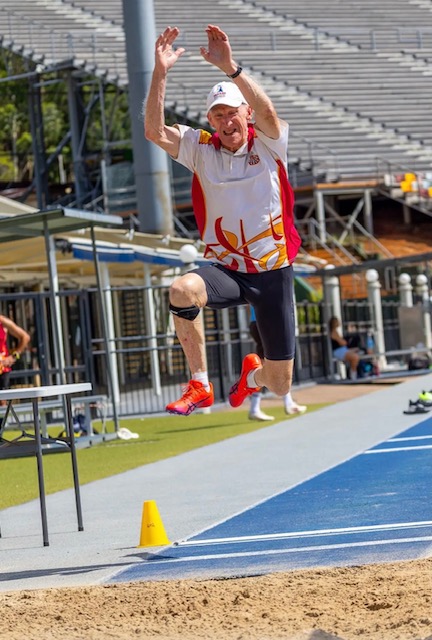 Masters athlete landing in the long jump pit