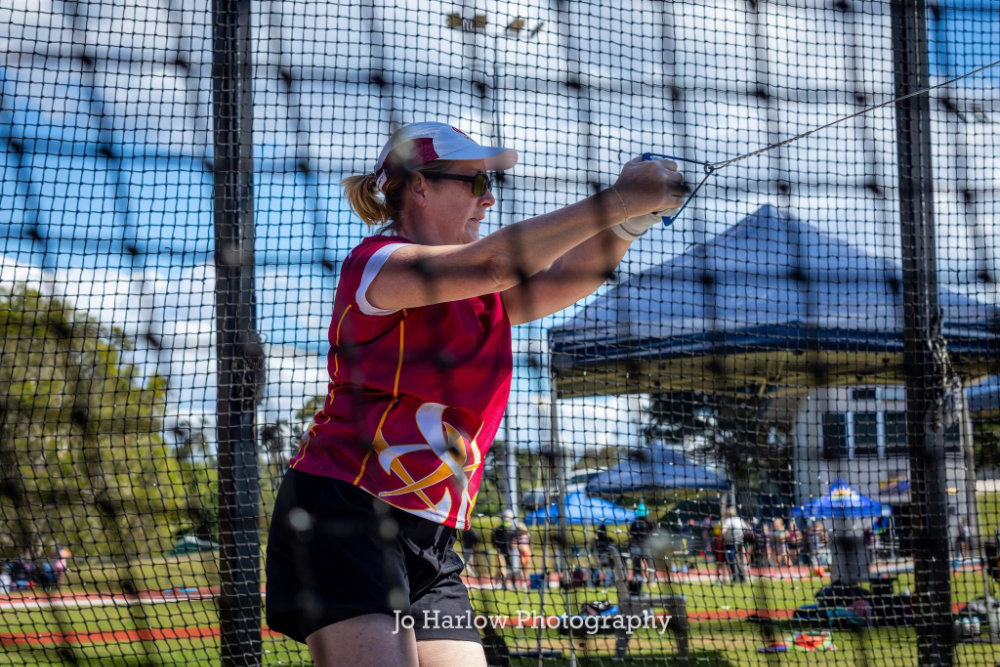 Kylie throwing hammer inside the cage