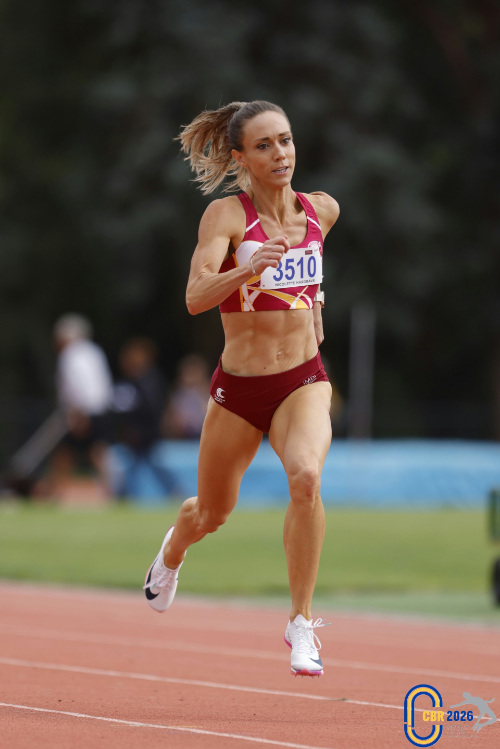 Nicolette Smith racing on the track in a maroon and gold crop top and briefs